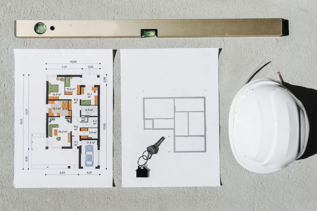 Property surveyor reviewing floor plans and building documents on site