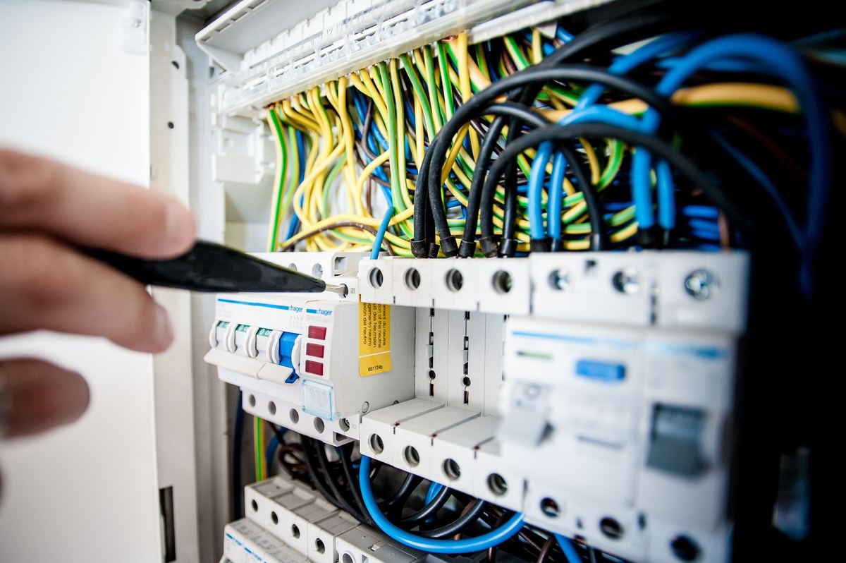 Electrician inspecting consumer unit for EICR